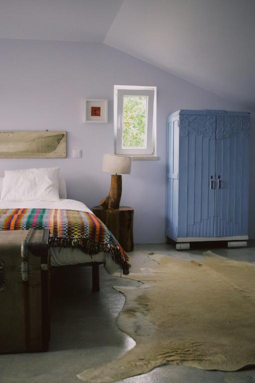 a bedroom with a bed and a blue cabinet at Casa Oliva - Casa da Mata in Porto de Mós