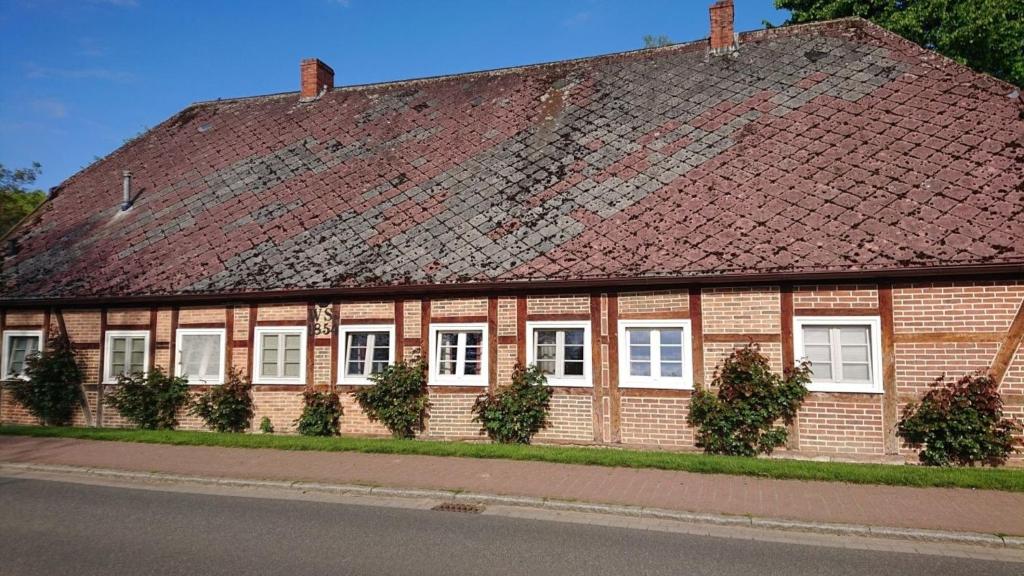 Lüdersburger Strasse 15d في Lüdersburg: مبنى من الطوب الأحمر بسقف صدئ