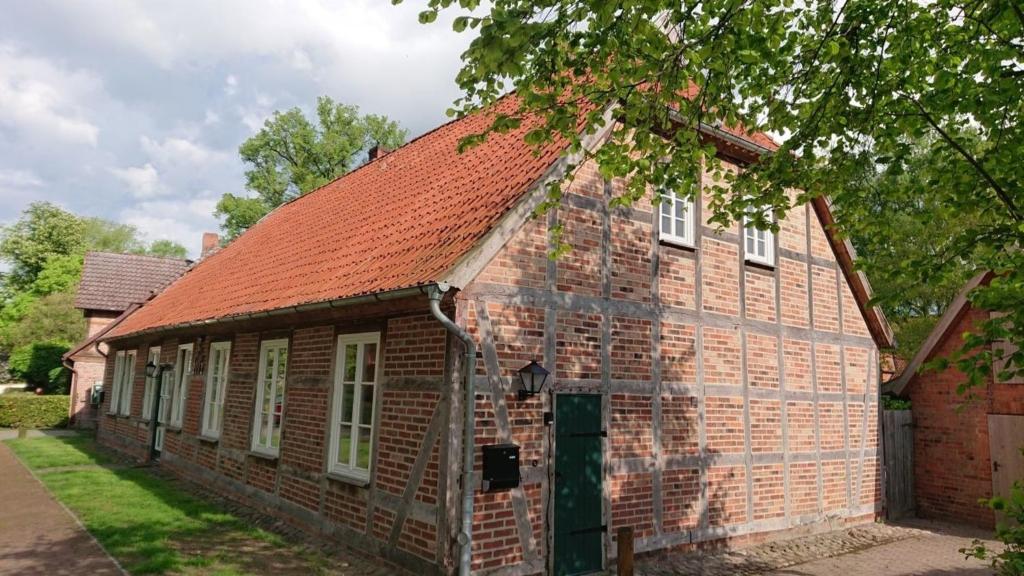 an old brick building with a red roof at Dachsbau - Kirchtwiete 3b in Lüdersburg