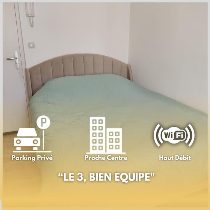 - un lit dans une chambre avec un panneau dans l'établissement LE 3, wifi, parking, centre, à Châteauroux
