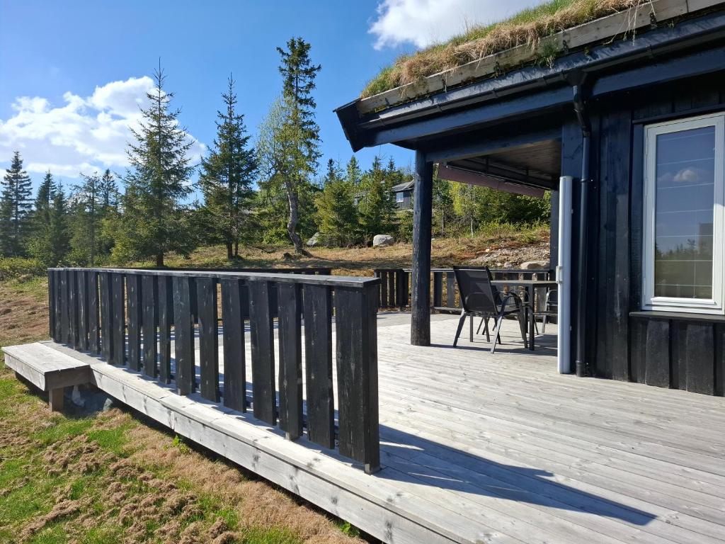 una terraza de madera con una mesa en una casa en Perfect location at Lifjell en Lifjell