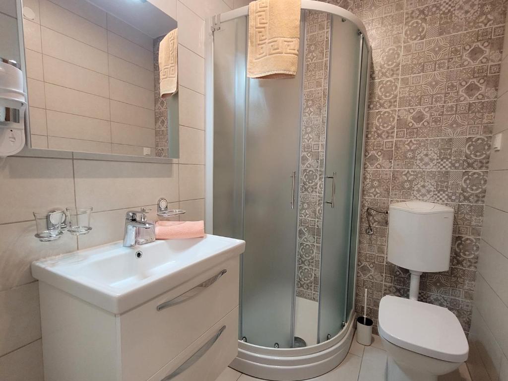 a bathroom with a sink and a shower and a toilet at Apartment Danica in Malinska