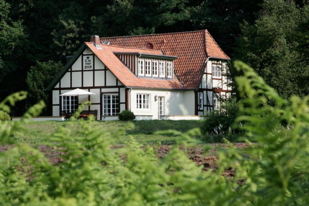 uma casa a preto e branco com um telhado vermelho em Alte Schäferei - Jägerstube em Lüdersburg