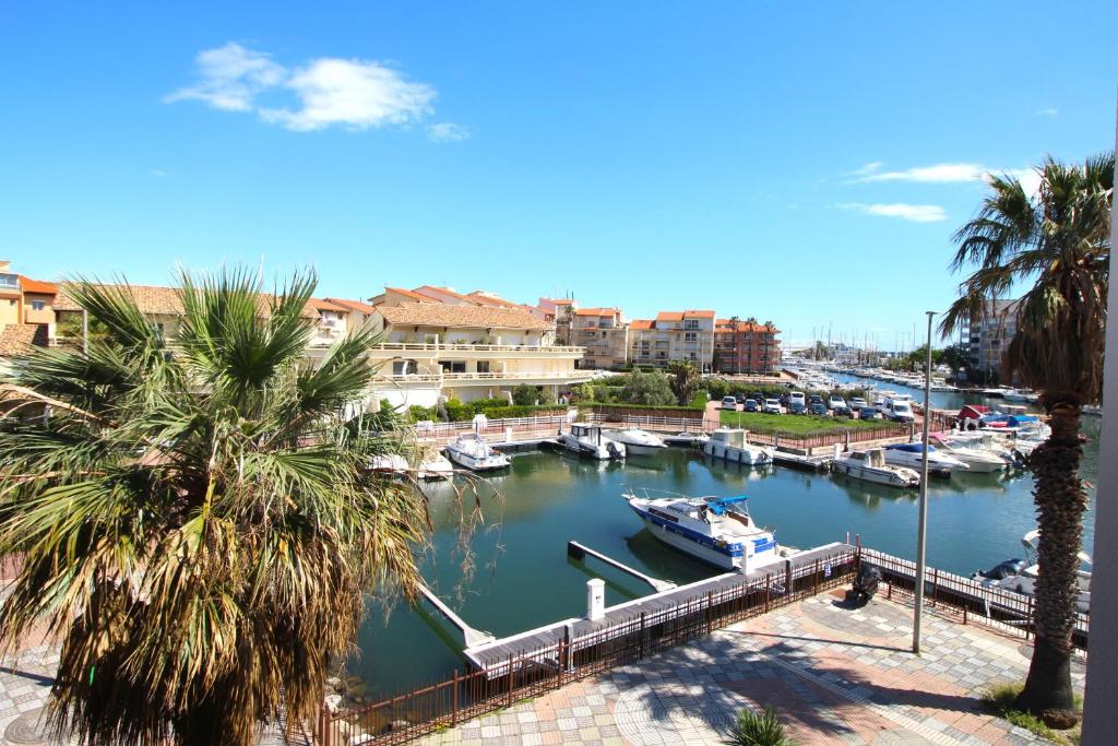 un bateau amarré dans un port de plaisance avec des palmiers dans l'établissement studio pour 4 vue marina, à Canet