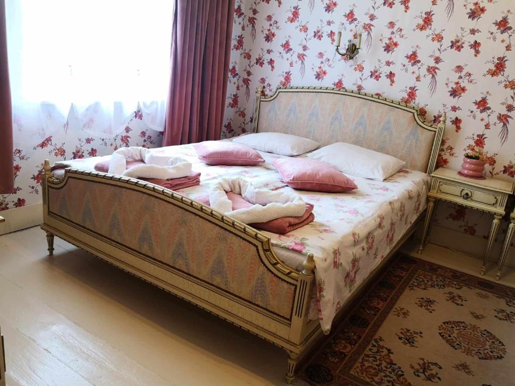 a bedroom with a bed with pink pillows at Raudtee in Viljandi