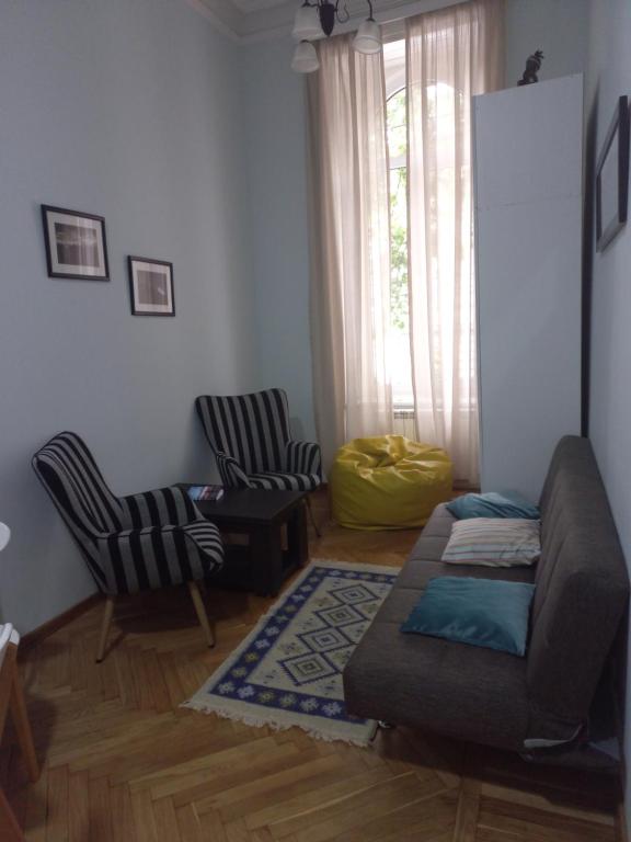 - un salon avec un canapé et deux chaises dans l'établissement Apartment on Vera, à Tbilissi