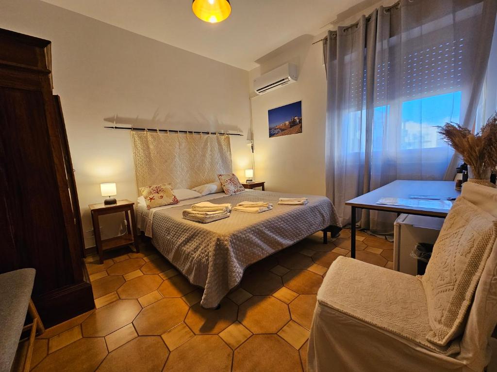 Schlafzimmer mit einem Bett, einem Tisch und einem Fenster in der Unterkunft Antonhouse Alghero in Alghero