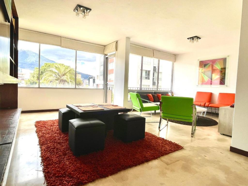 sala de estar con mesa y sillas verdes en ItsaHome Aparments - Casa del Parque, en Quito