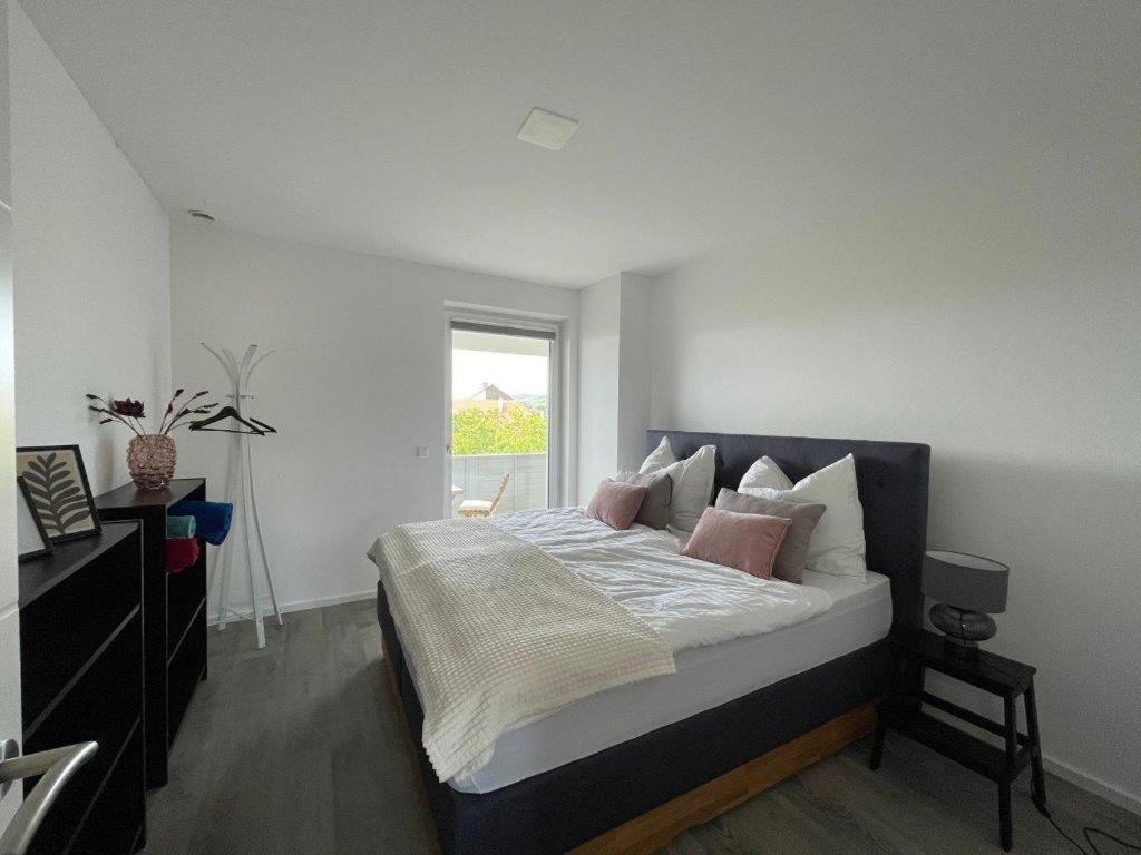 - une chambre avec un lit doté d'oreillers roses et d'une fenêtre dans l'établissement Penthouse Langenloiserberg, à Krems an der Donau