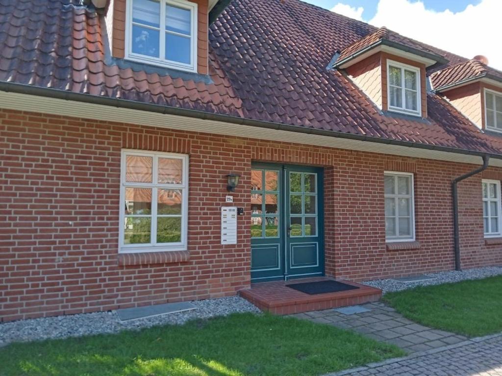 a red brick house with a green door at Neubau 8 in Lüdersburg