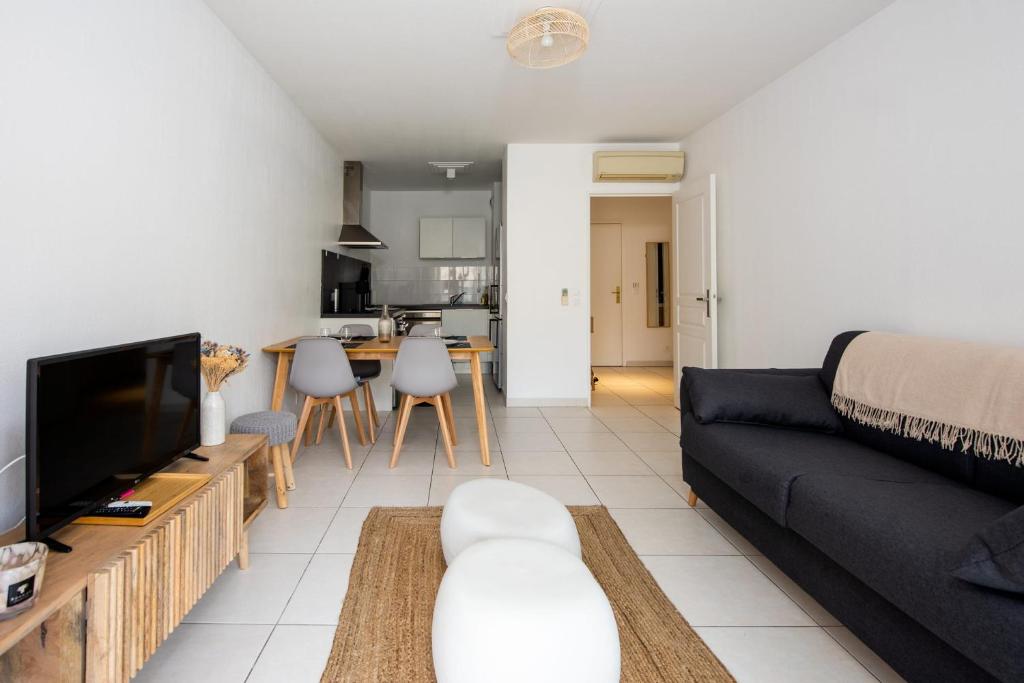 un salon avec un canapé et une télévision dans l'établissement Appartement Antibéa - Welkeys, à Antibes