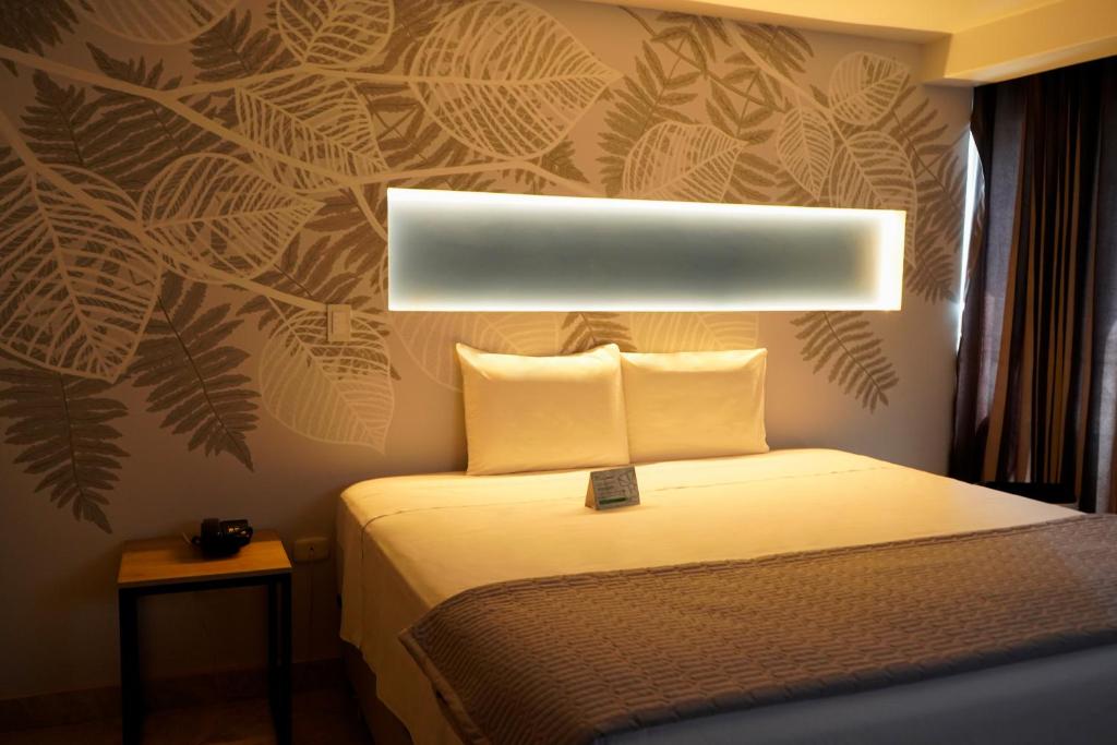 1 dormitorio con 1 cama con luz sobre ella en Hotel Santa Rosa en Chiclayo