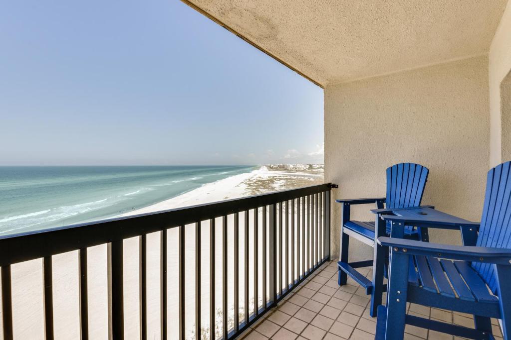 two blue chairs sitting on a balcony looking at the beach at Emerald Dreams Lakefront PCB Vacation Rental! in Panama City Beach