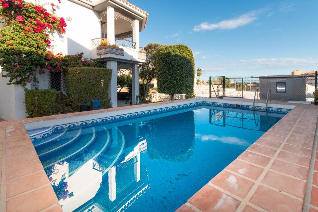 a swimming pool in front of a house at Villa Cotomar in Rincón de la Victoria