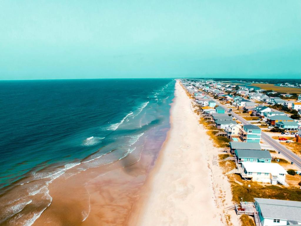 an aerial view of a beach with houses and the ocean at Bluewater Downtown Cottage in Wilmington