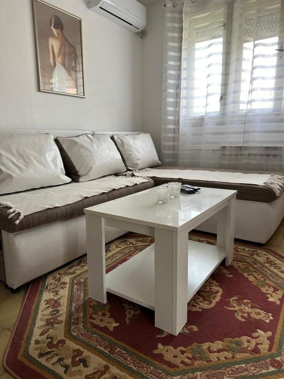 ein Wohnzimmer mit einem Sofa und einem Couchtisch in der Unterkunft Day & Night Apartment in Ćuprija