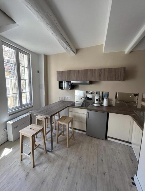 une cuisine avec une table et des chaises dans une pièce dans l'établissement Charmant Duplex Intra-Muros, à Avignon