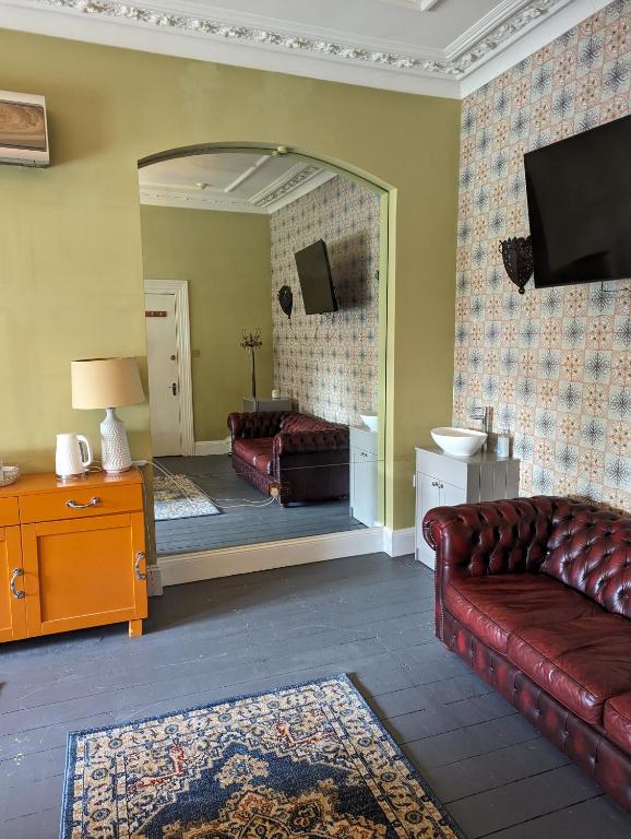 un soggiorno con divano e specchio di Caspian Hotel a Londra