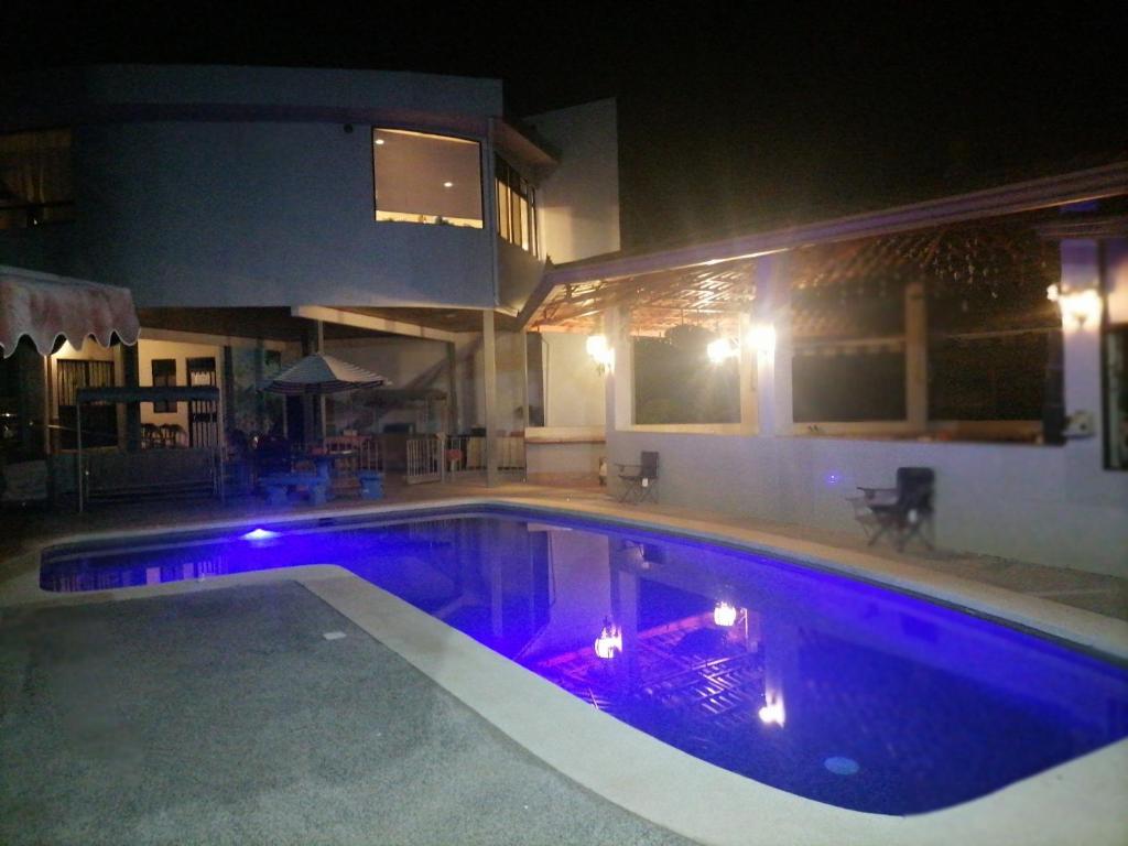 una piscina notturna con luci viola di Villa Garita Inn a La Garita