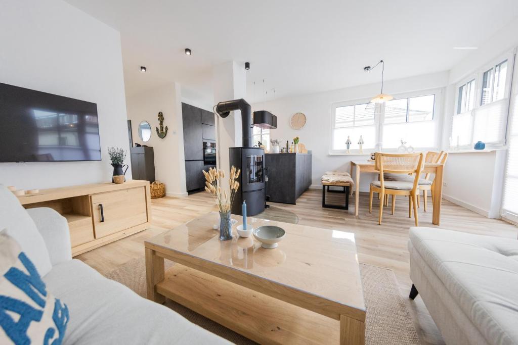 a living room with a couch and a table at Haus Q Superior - Hälfte 1 in Zingst