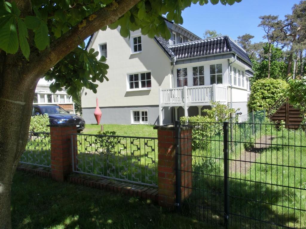 einen Zaun vor einem weißen Haus in der Unterkunft Ferienwohnung MH3 "Summer Breeze" in Rostock