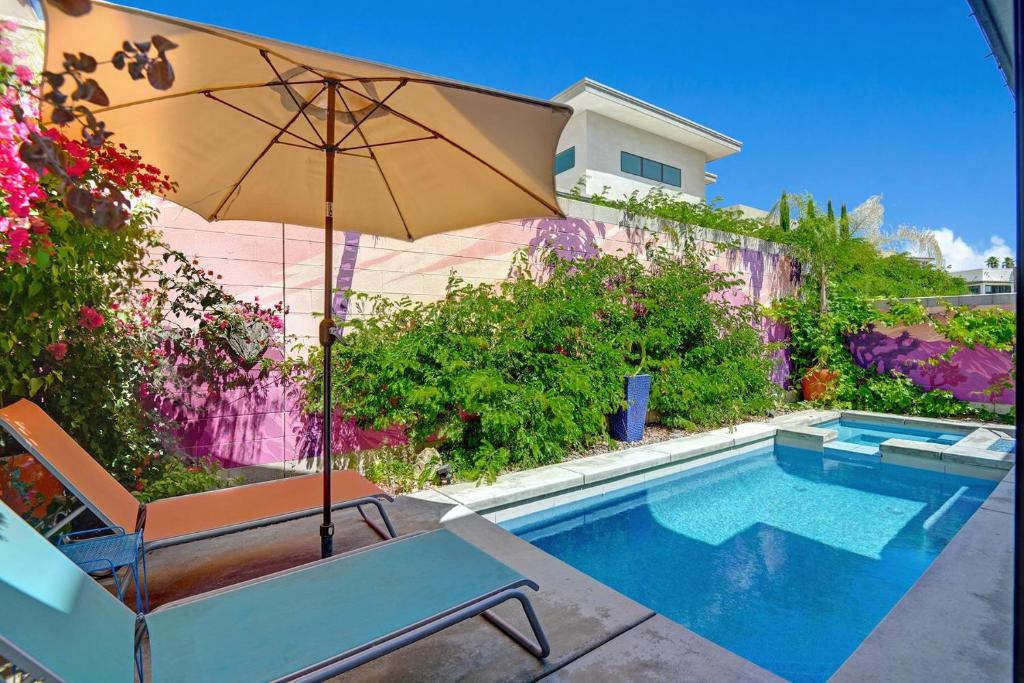 棕櫚泉的住宿－The Luxe Vibe，游泳池旁的椅子和遮阳伞