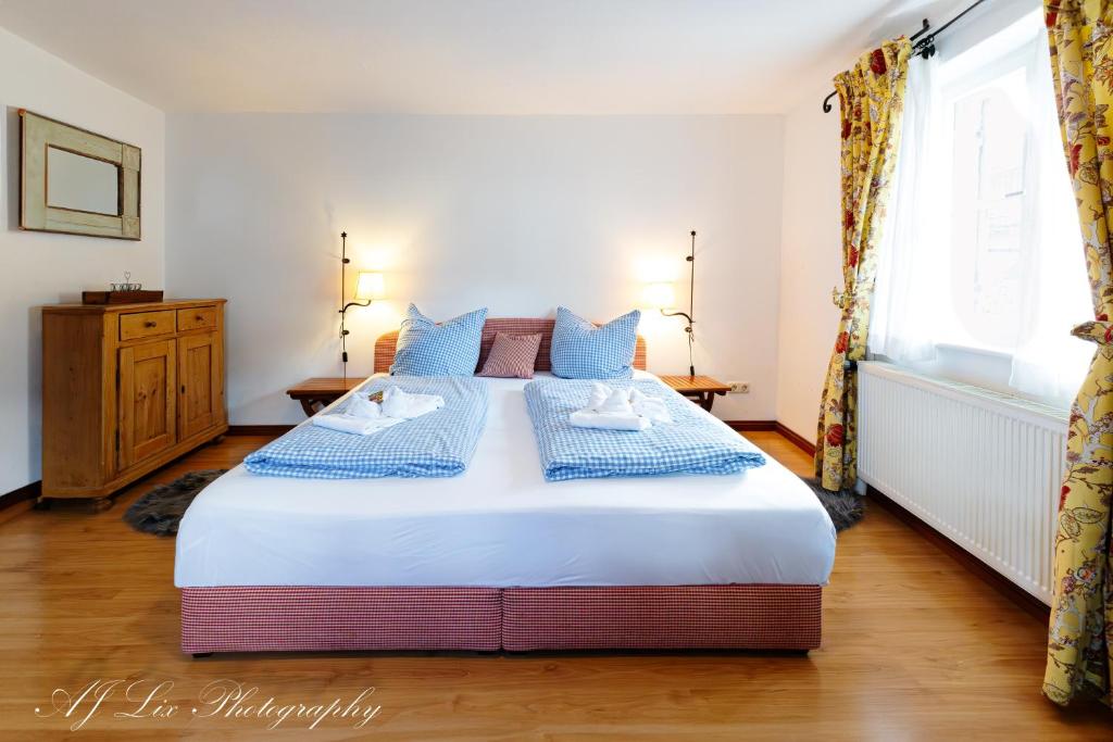 a bedroom with a large bed with blue pillows at Fewo Jaisweg in Mittenwald