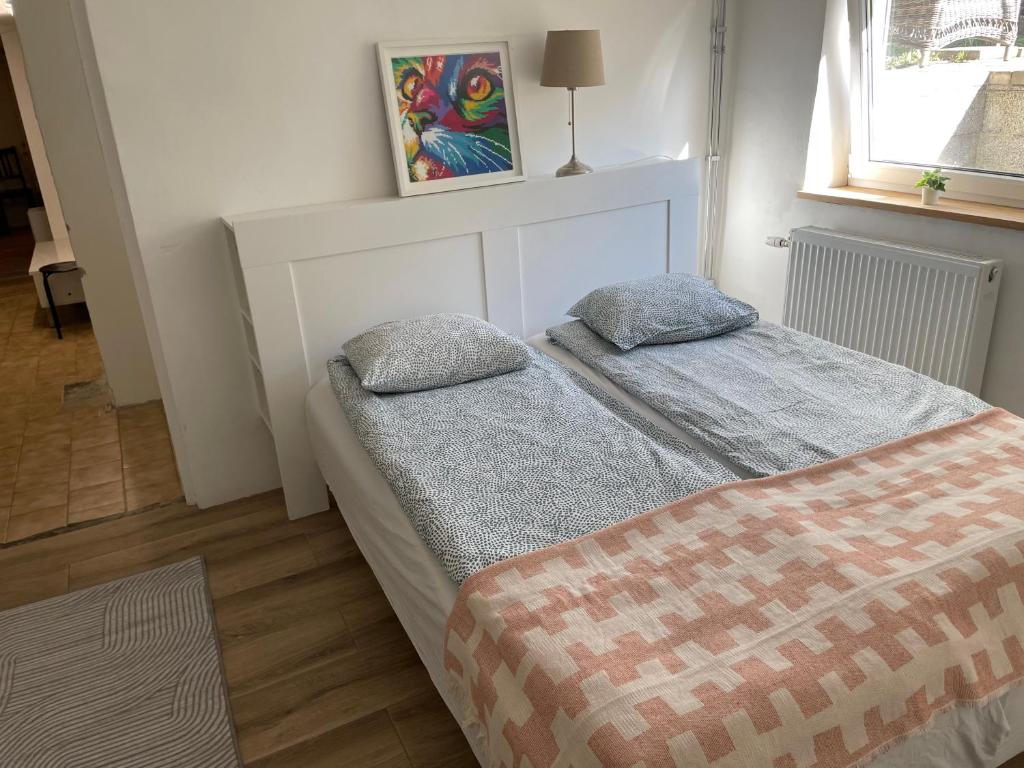 ein Schlafzimmer mit einem Bett mit zwei Kissen darauf in der Unterkunft Vollmers in Malmö