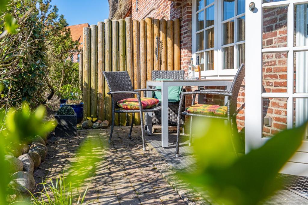 a patio with a table and chairs and a fence at Altstadttor 5 in Westerland