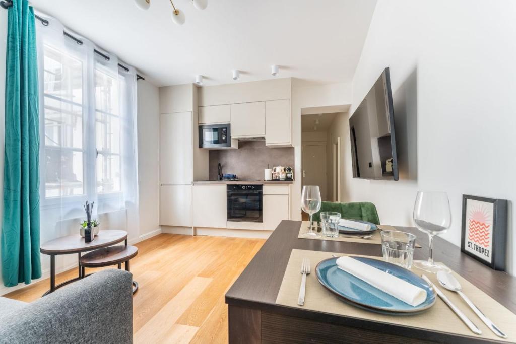 Il comprend un salon avec une table à manger et une cuisine. dans l'établissement Luxurious apartment in center of Paris, à Paris