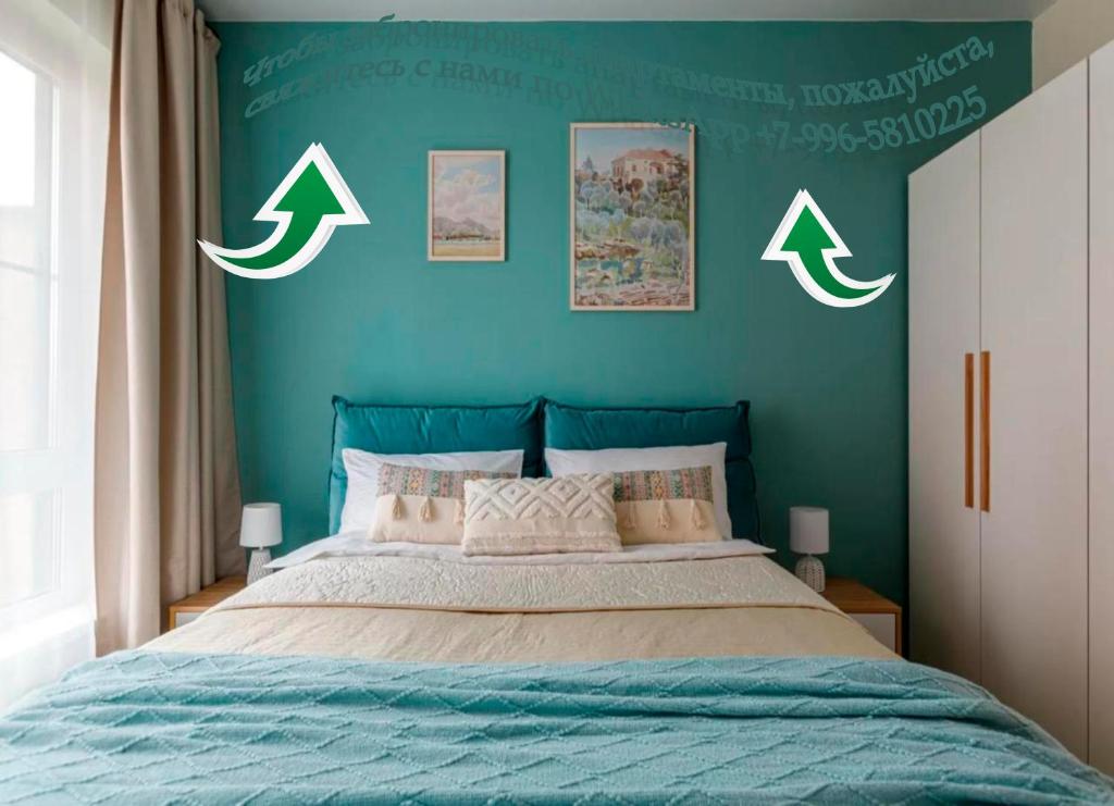 Современные Апартаменты с 2 комнатами : غرفة نوم بسرير بأربعة سهام على الحائط