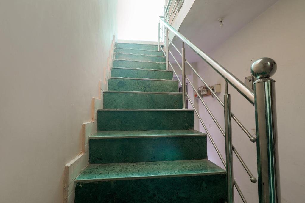 una escalera con escalones verdes y una ventana en OYO Siddhi Vinayak Guest House, en Gwalior