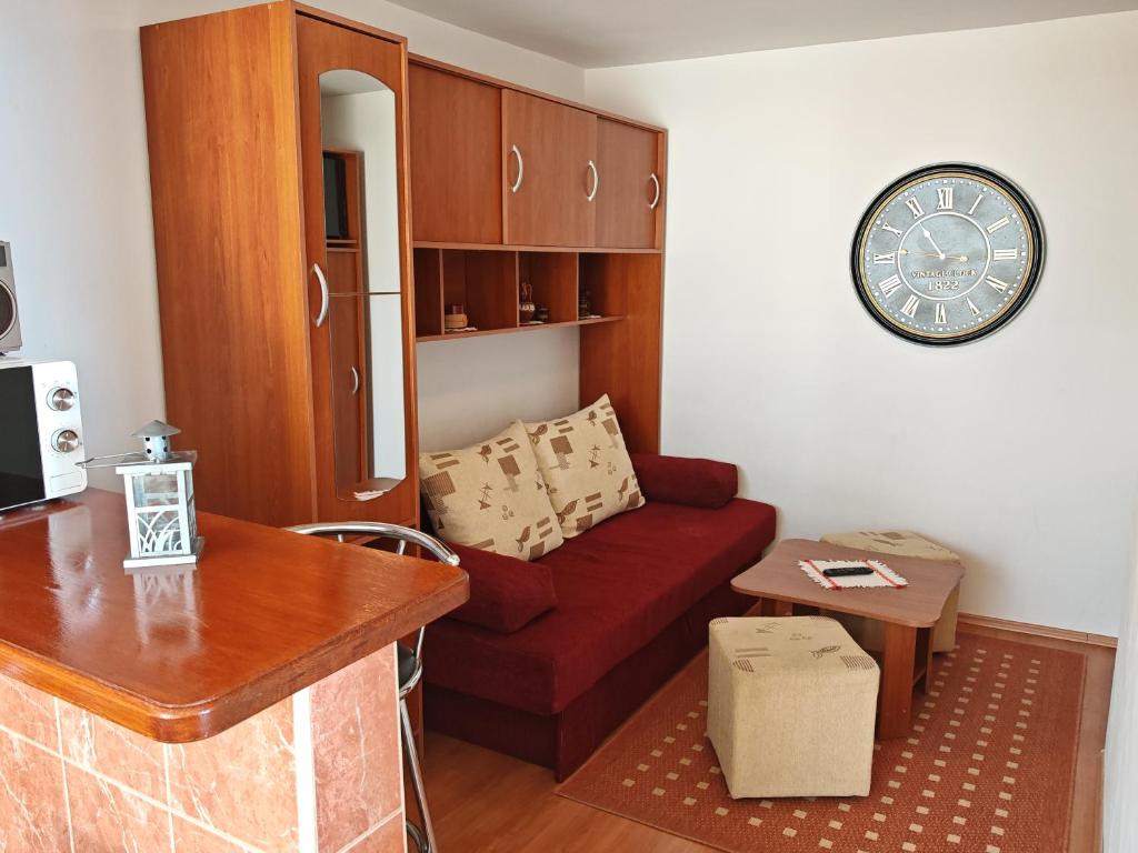 a living room with a red couch and a clock at Apartman Vera in Crikvenica