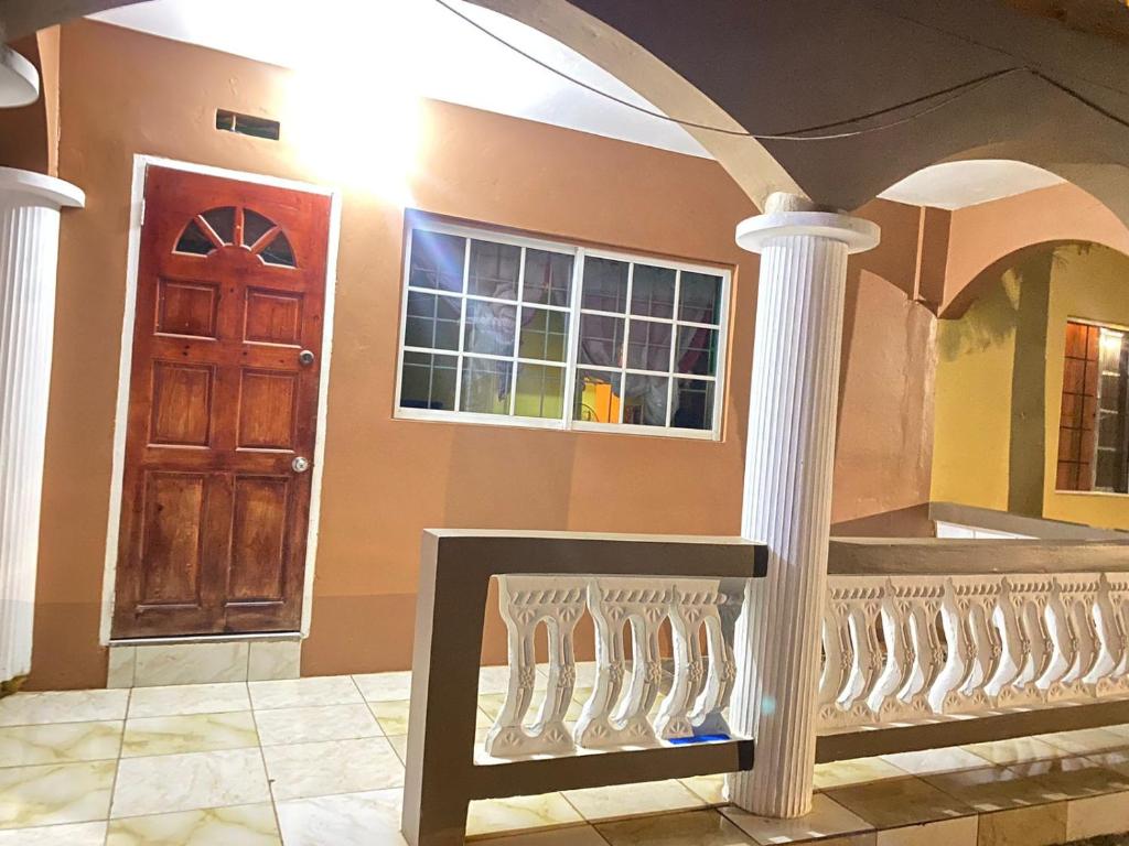a room with a door and a staircase with columns at Pinevalley Rental Suites 2b ONE BEDROOM in Mandeville