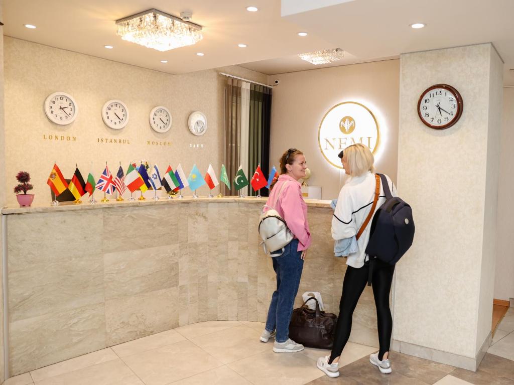 twee vrouwen aan een toonbank in een winkel bij Nemi Hotel Baku in Baku