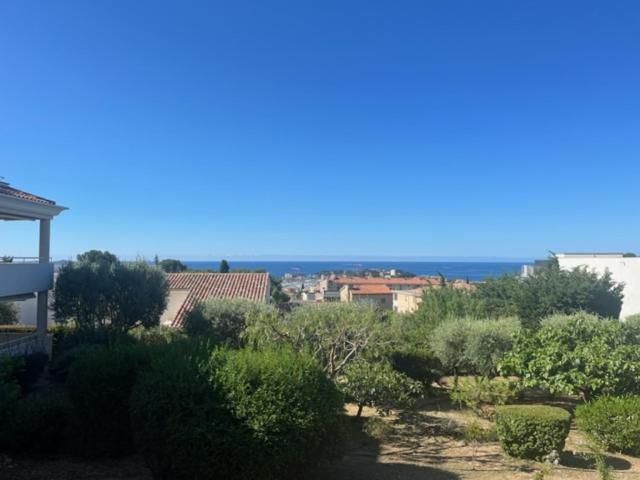 Elle offre une vue sur un jardin avec des buissons et des arbres. dans l'établissement Les Villas Toscane, à Bandol