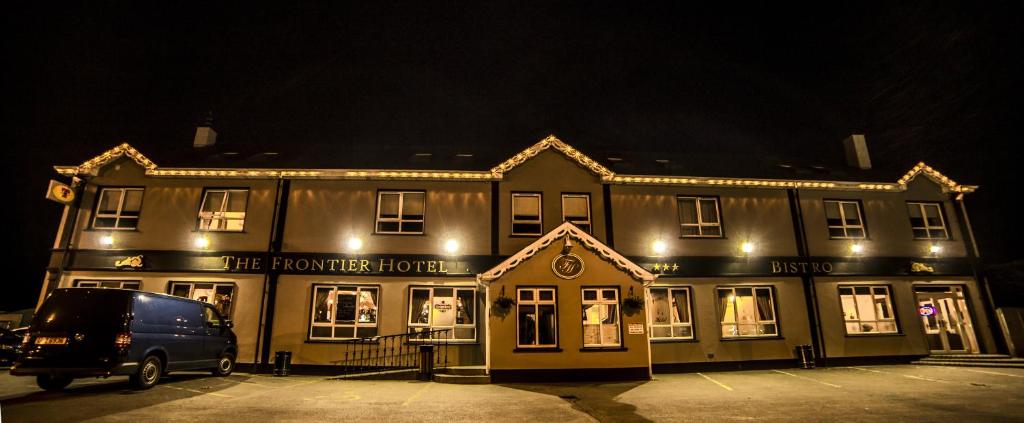 um edifício com uma carrinha estacionada em frente em The Frontier Hotel em Bridgend