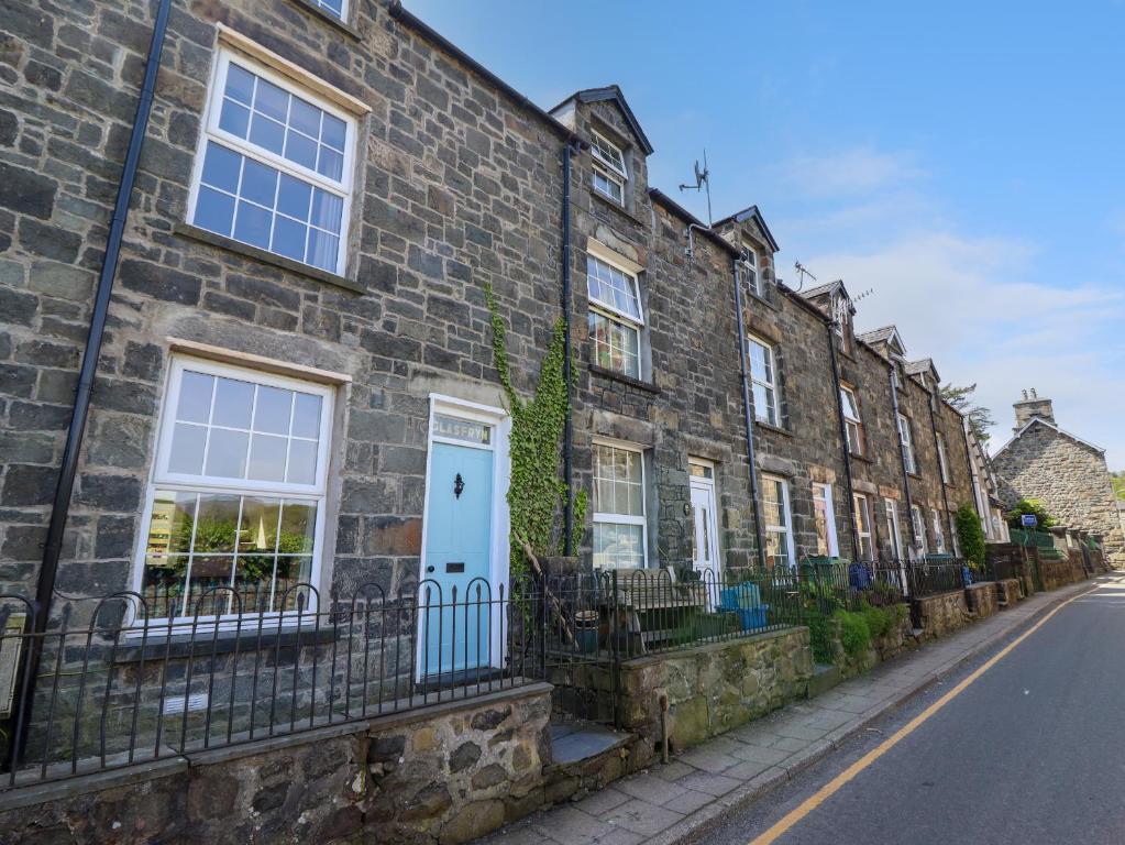 a row of brick houses with a blue door at Glasfryn in Dolgellau
