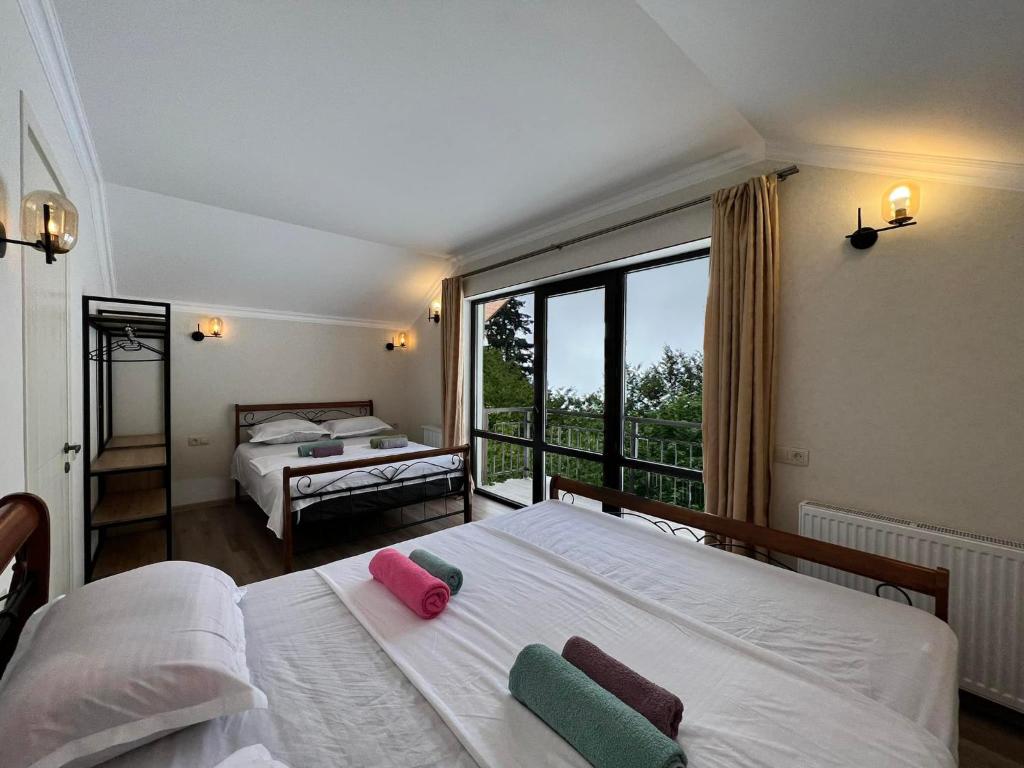 1 dormitorio con 2 camas y ventana grande en Mount Inn Villa, en Bakuriani