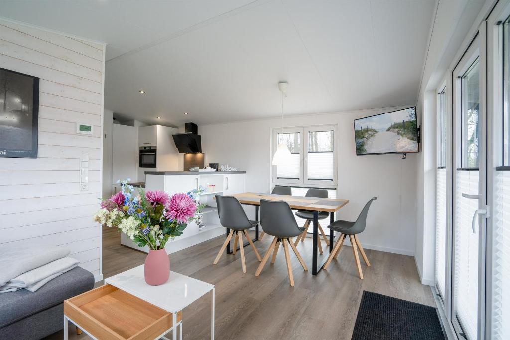 a living room and dining room with a table and chairs at Ostseecamp Chalet Haffkrug No 55 in Scharbeutz