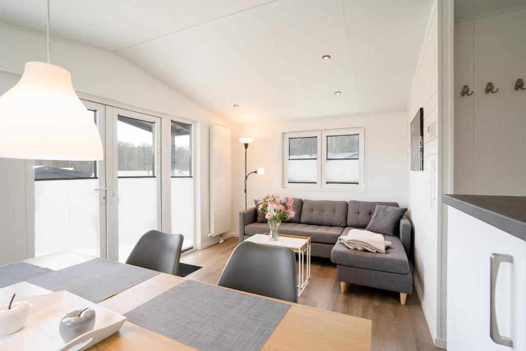 a living room with a couch and a table at Ostseecamp Chalet Haffkrug No 59 in Scharbeutz