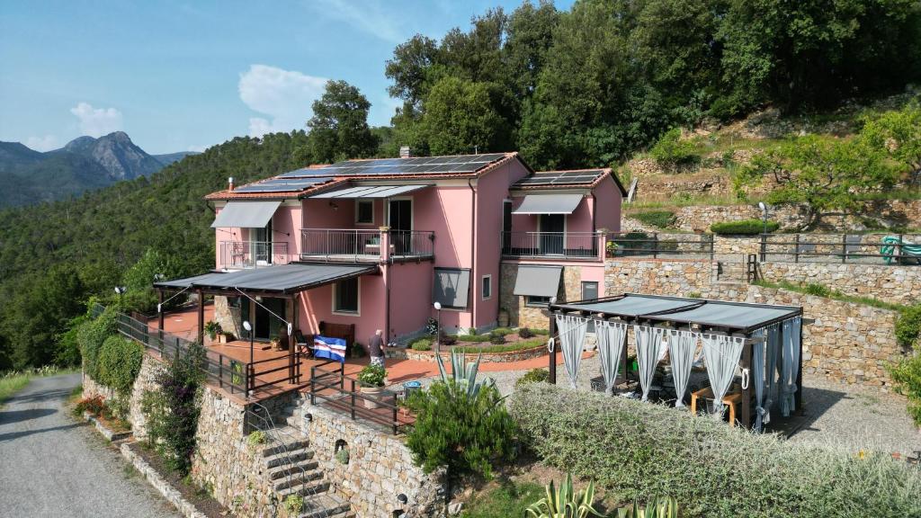a pink house on the side of a mountain at A Munta di Povei in Casarza Ligure
