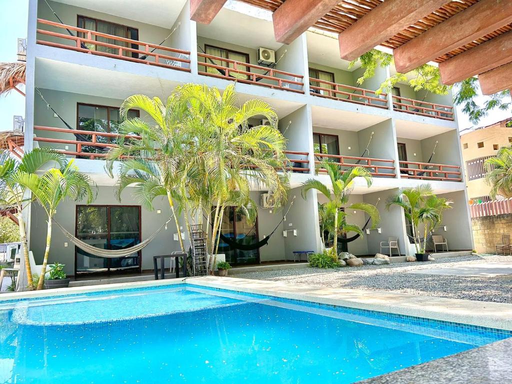 um hotel com piscina em frente a um edifício em Hotel Aldea Sol em Zihuatanejo