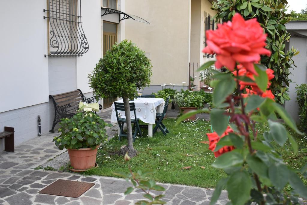 een tuin met een tafel, stoelen en bloemen bij La Casa dei Nonni in Certaldo