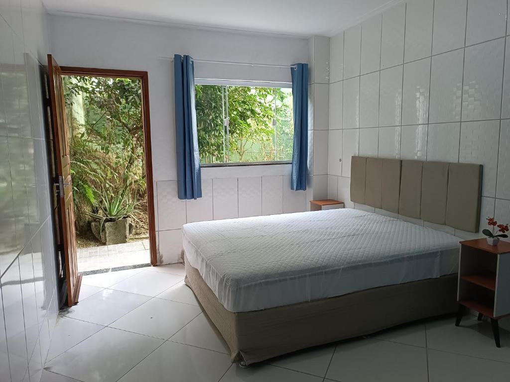 um quarto com uma cama e uma janela em Casa familiar com piscina Penedo RJ em Penedo