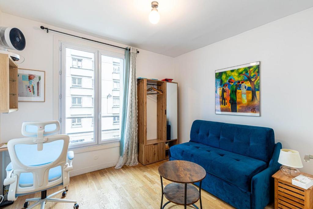 un salon avec un canapé bleu et une chaise dans l'établissement GuestReady - Cozy Retreat near Place de la Nation, à Paris