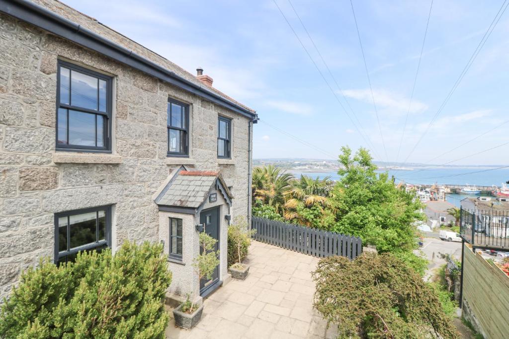 an exterior view of a stone house with a balcony at Rose Villa in Newlyn