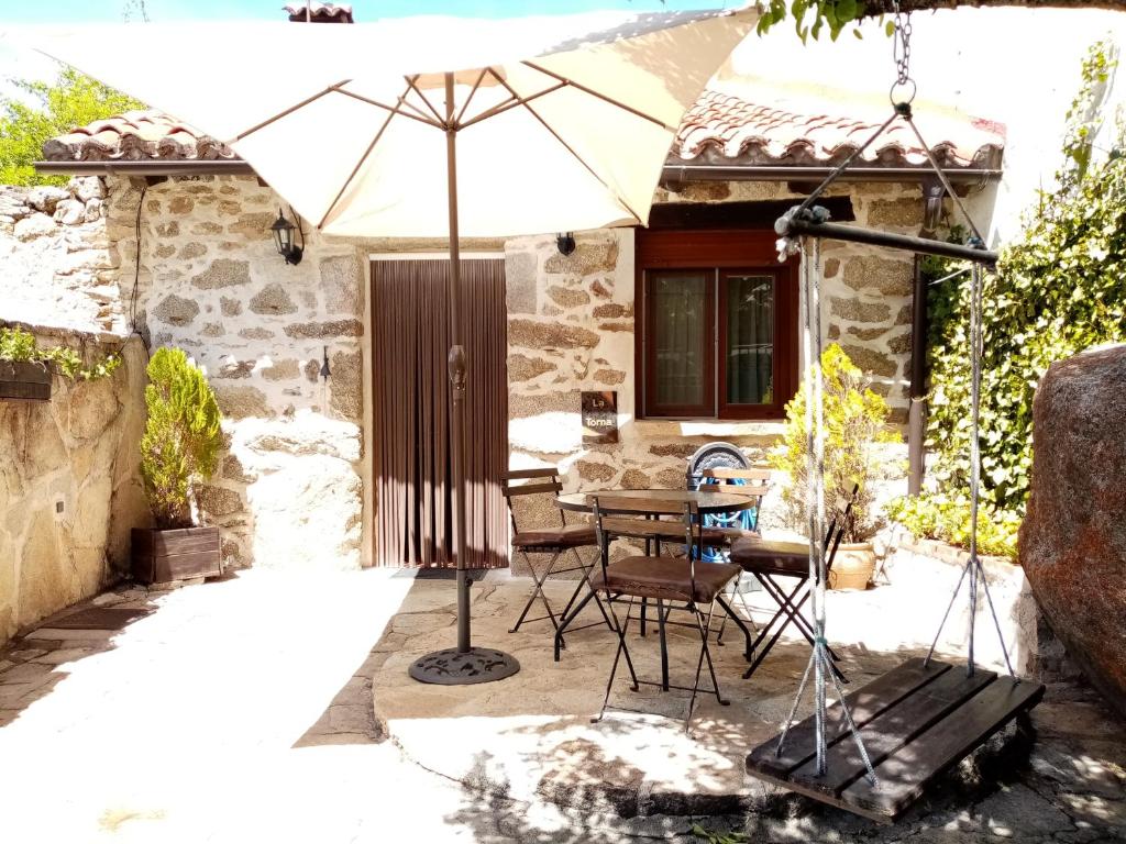 patio con ombrellone, tavolo e sedie di La torna a Navarredonda de Gredos