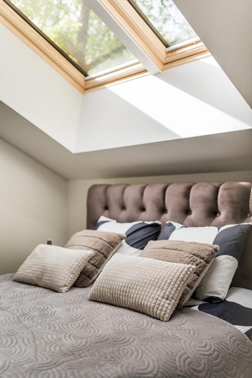 a bedroom with a bed with pillows and a skylight at Riverra House - Two-bedroom Apartment in Kaunas