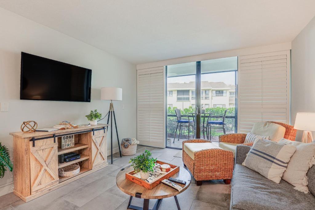 a living room with a couch and a tv at Fort Pierce Condo with Screened Porch Walk to Beach in Fort Pierce